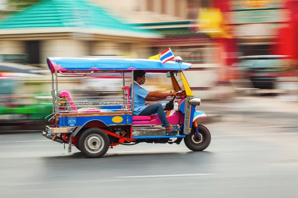 Colorful tuk tuk speeding through Bangkok streets